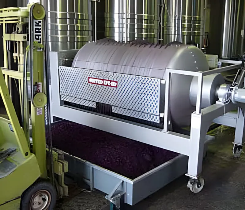 酒庄中的大型圆柱形压酒机,可见深色葡萄酒或葡萄果醪,用于将皮和籽与葡萄酒分离。