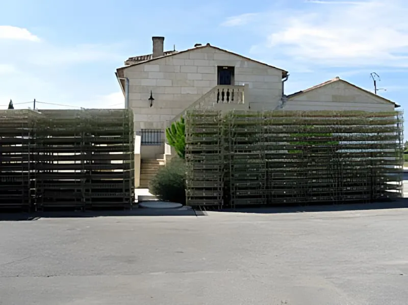 石制建筑外堆叠的金属丝网箱,用于装瓶过程中储存和运输酒瓶。